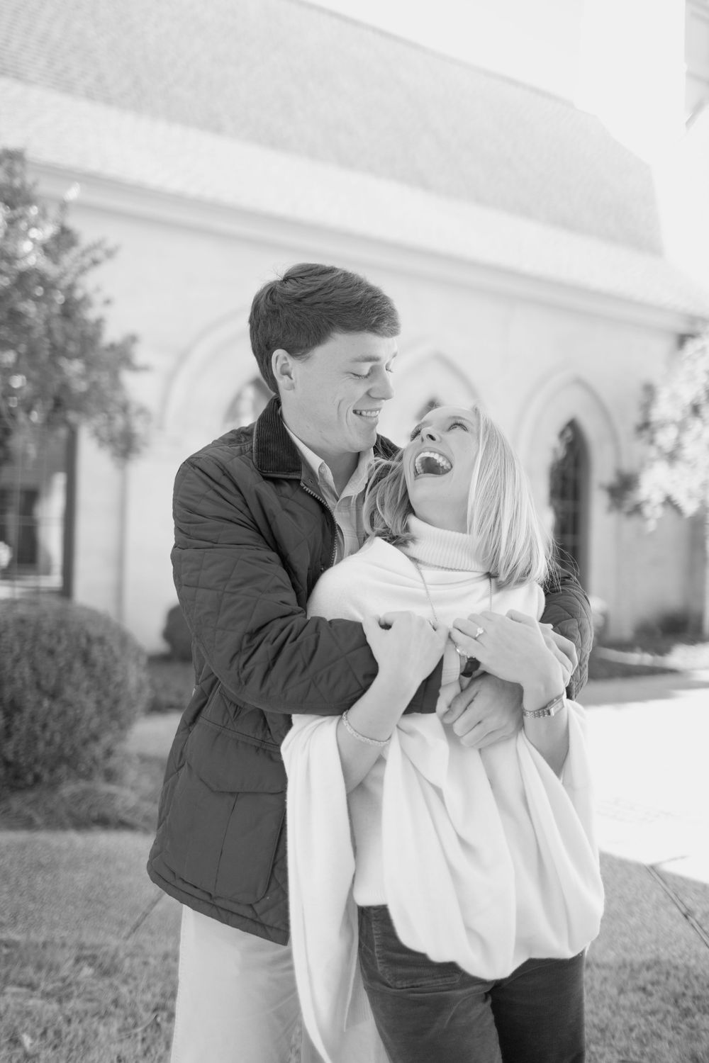Black and white photos of couple sharing joyful moments outside a white building.