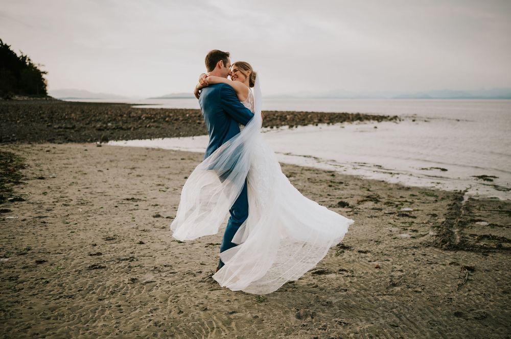 Wedding photography of couple on Williams Beach, spinning during golden hour with ocean, and mountains in background