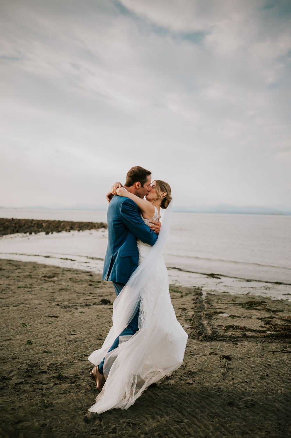 Wedding photography of couple on Williams Beach, spinning during golden hour with ocean, and mountains in background