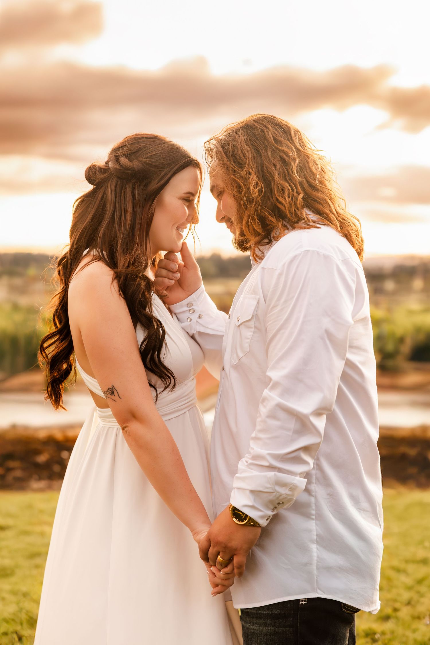 Romantic couple shares an intimate moment at sunset in a scenic outdoor setting with warm golden light.