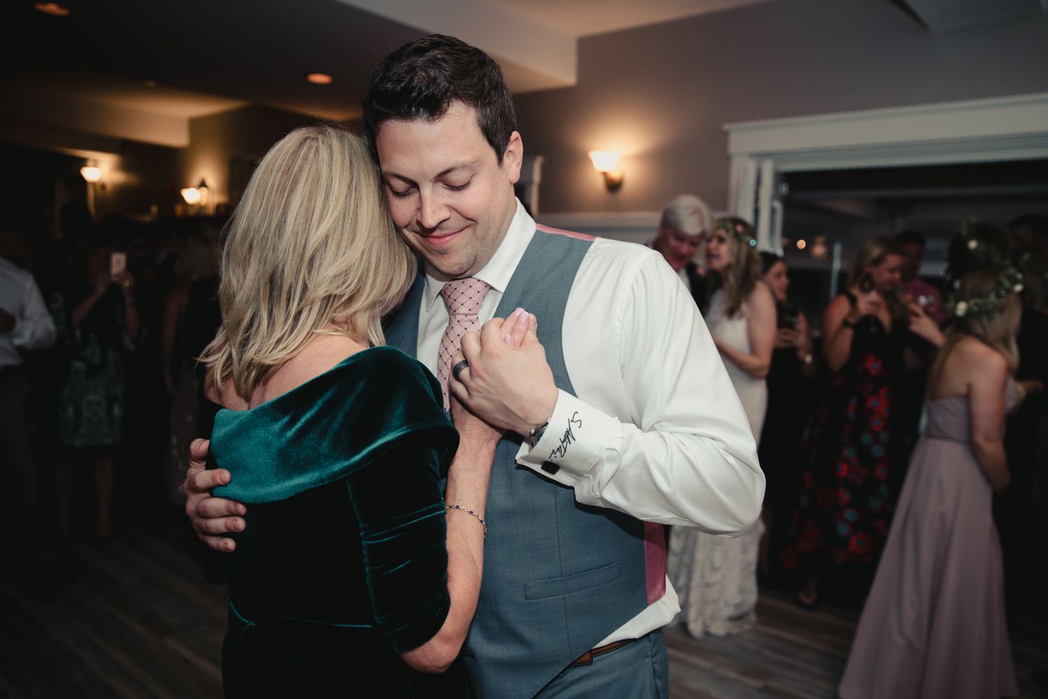 Couple sharing a romantic slow dance embrace at a wedding reception in an elegant venue.