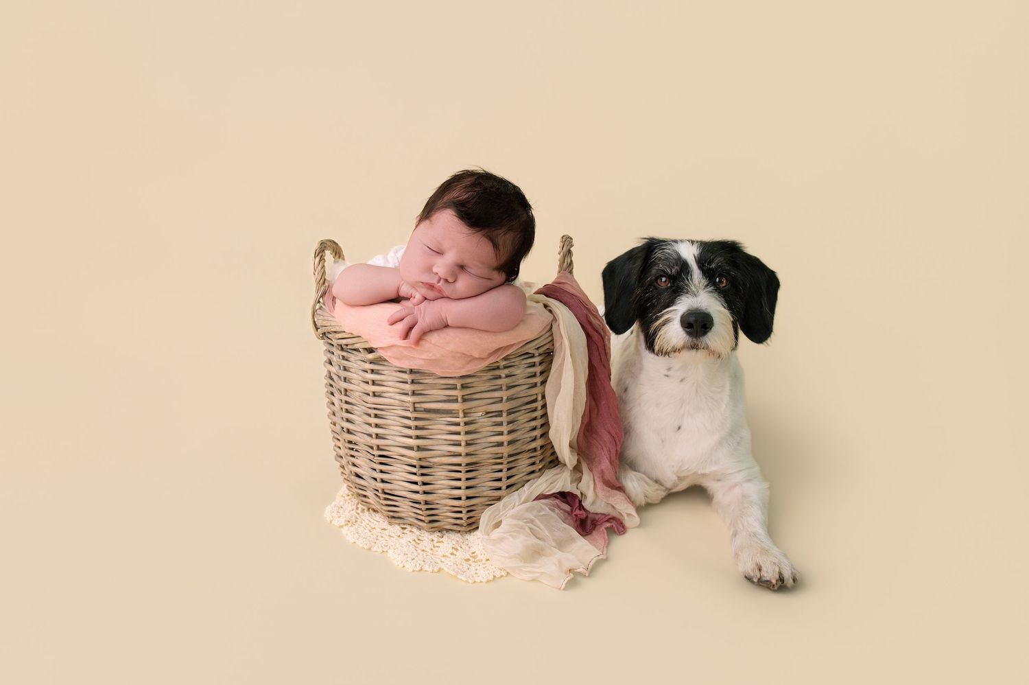 Black and white photo of new parents tenderly holding their newborn baby wrapped in white lace.
