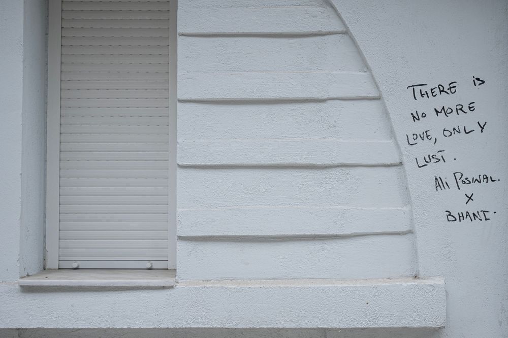A white wall with multiple pieces of paper posted in a row.
