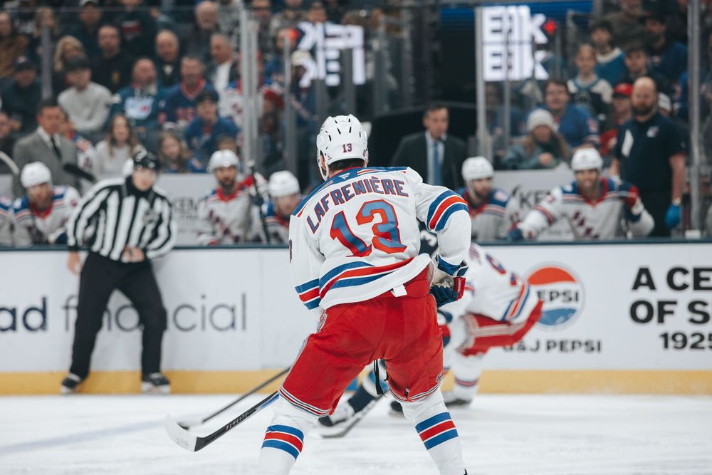 NHL hockey player in New York Rangers jersey number 13 skates on ice during professional game.