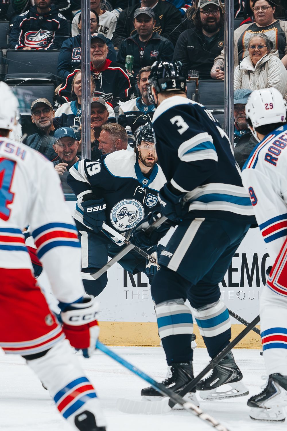 NHL hockey players from the Los Angeles Kings and New York Rangers battle for the puck during an intense game.