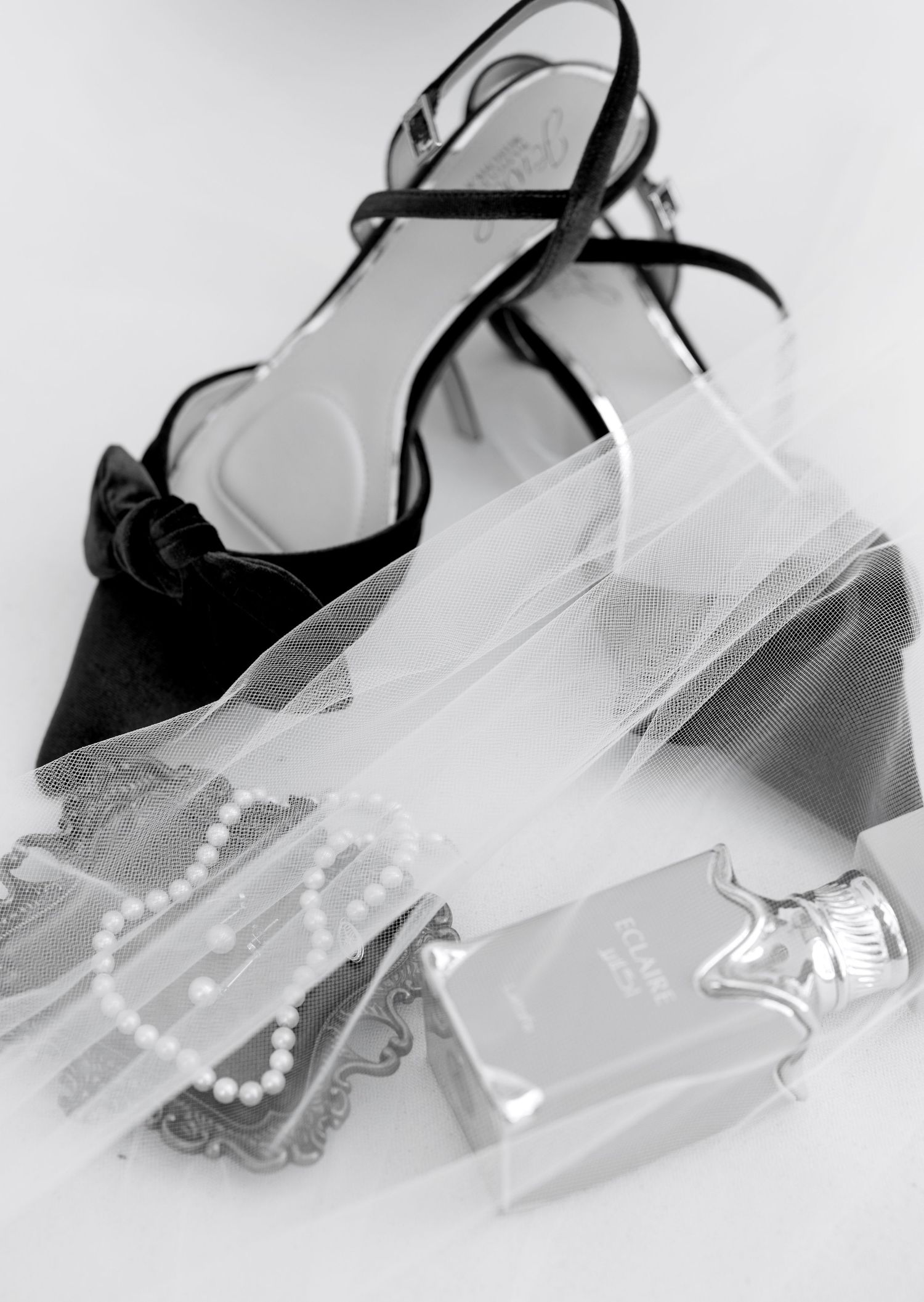 A series of four black and white images showing elegant women's high heel shoes with decorative pearl details.
