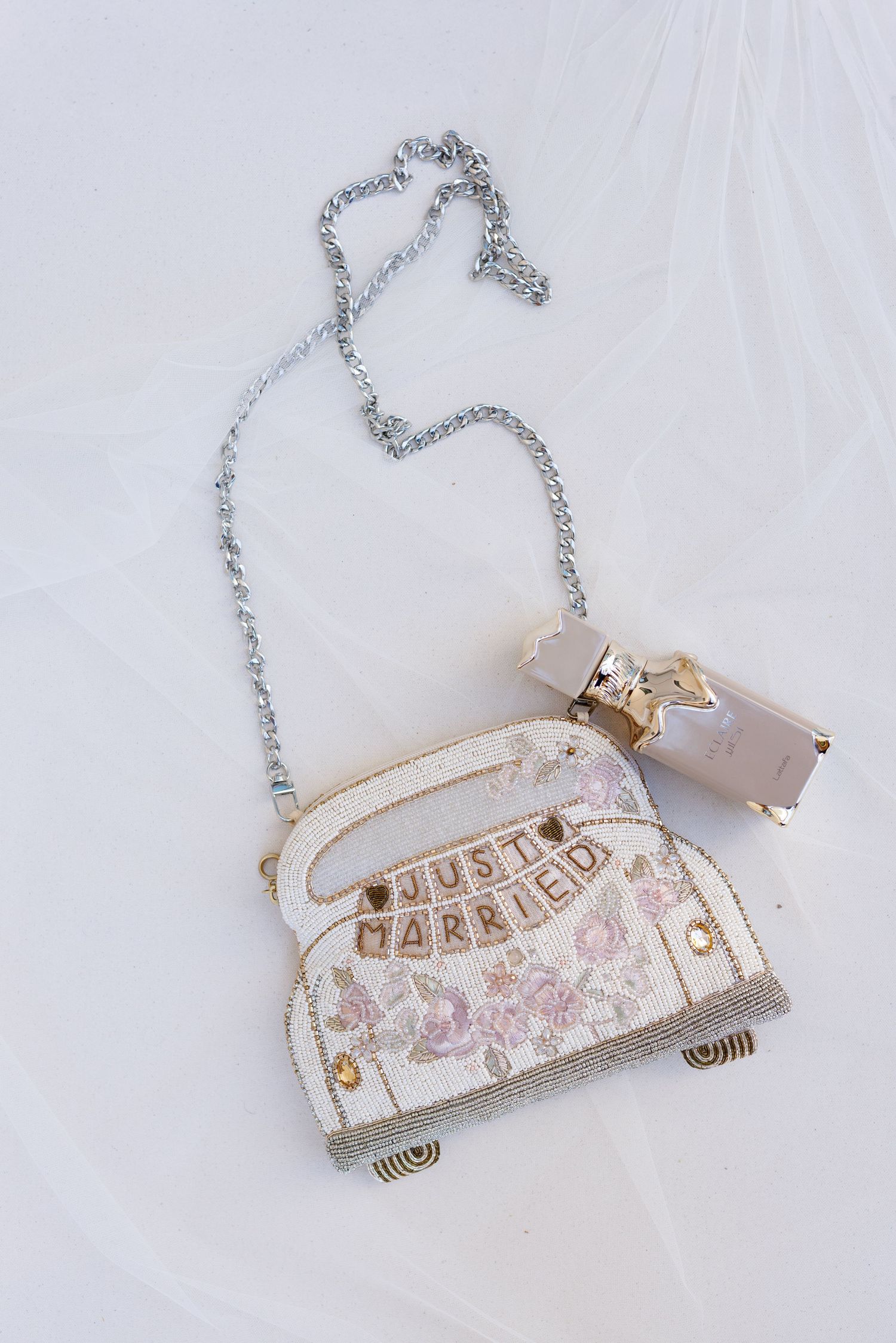 Vintage-inspired necklace with 'Just Married' text on a decorative white and floral patterned car pendant.