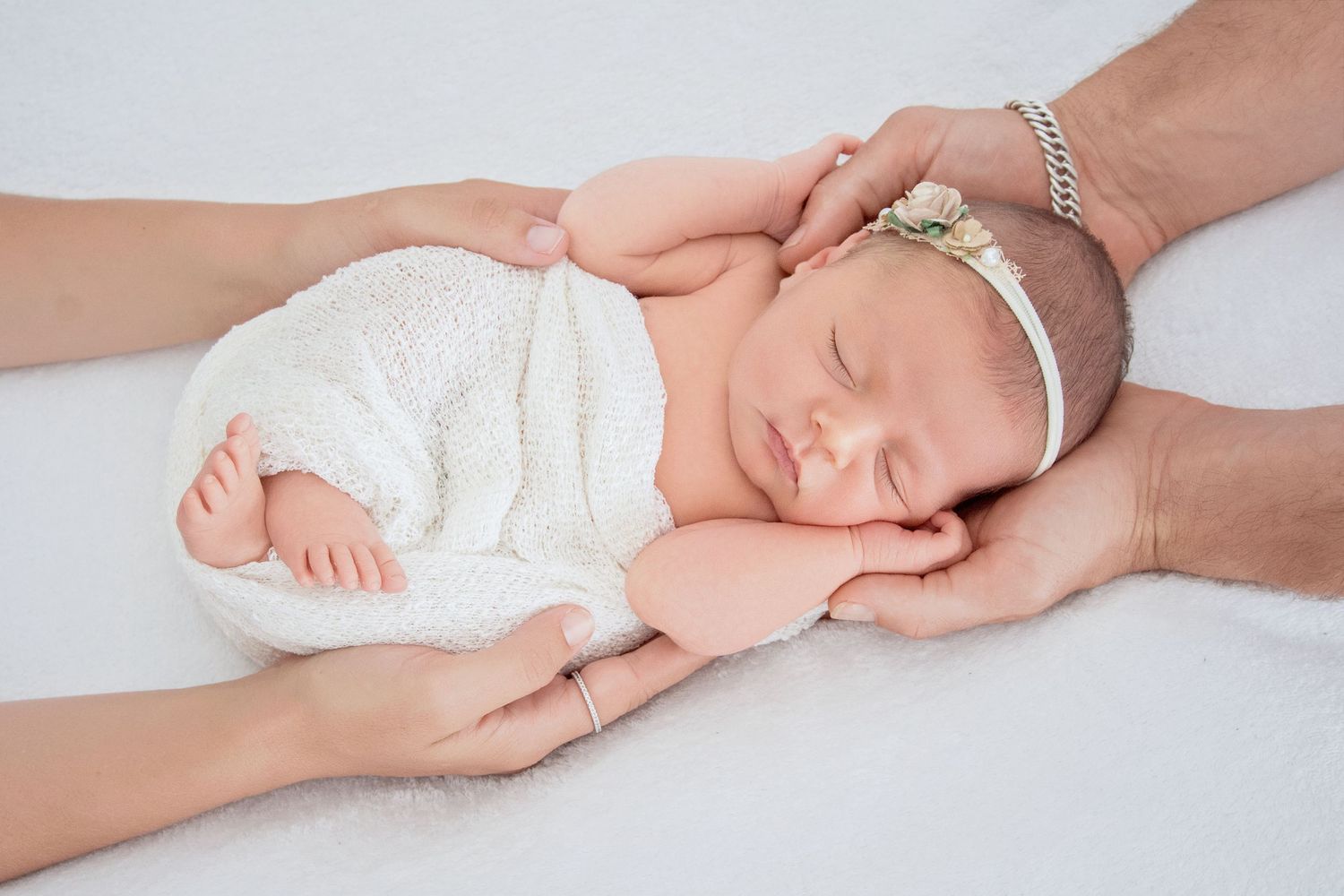 newborn baby girl in her parents has for a beautiful safe photo