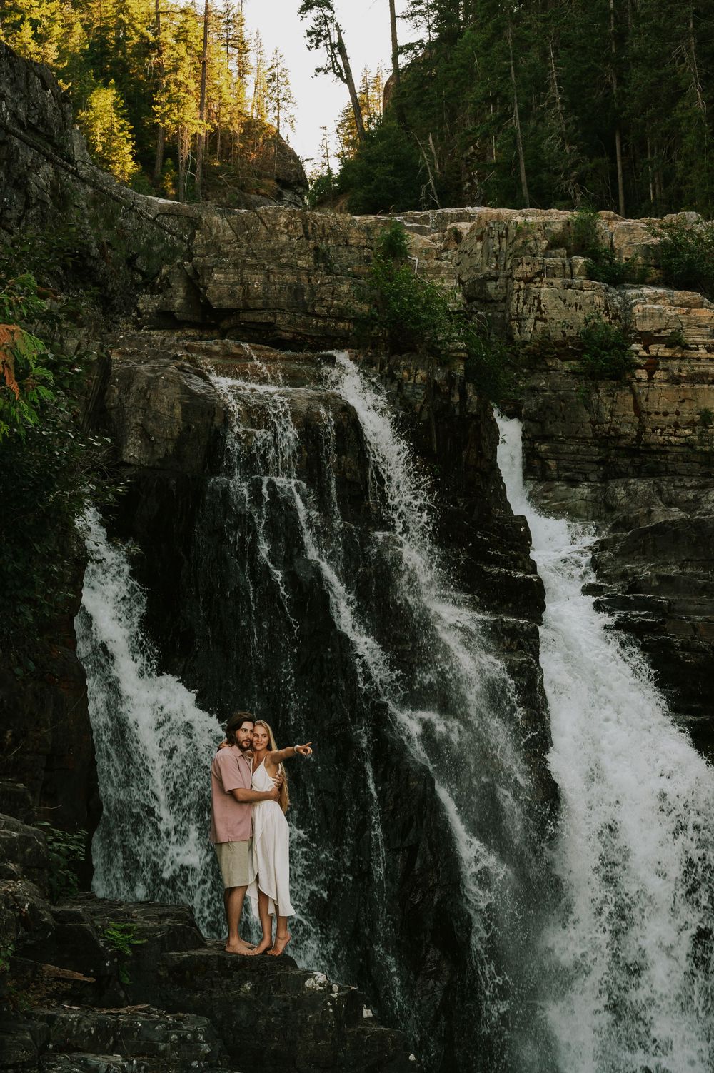 Couple adventure photoshoot session Vancouver island taken by professional photographer of couple standing by lower Myra Waterfalls