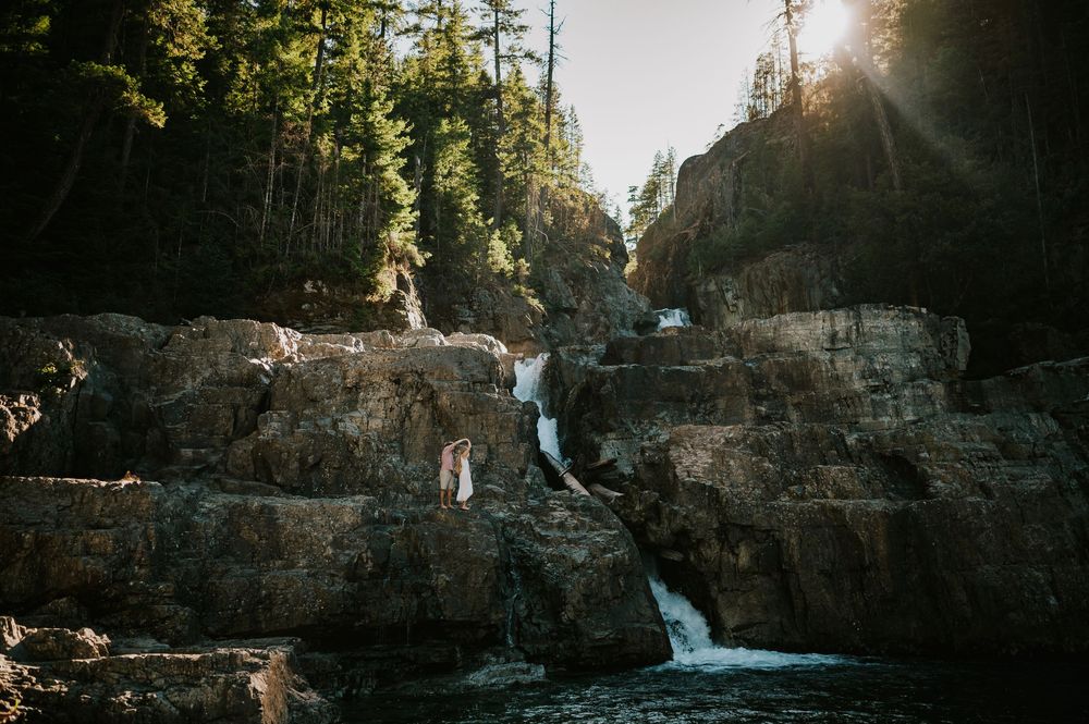 Couple adventure photoshoot session at Myra Falls on Vancouver island taken by professional photographer of couple walking by waterfall