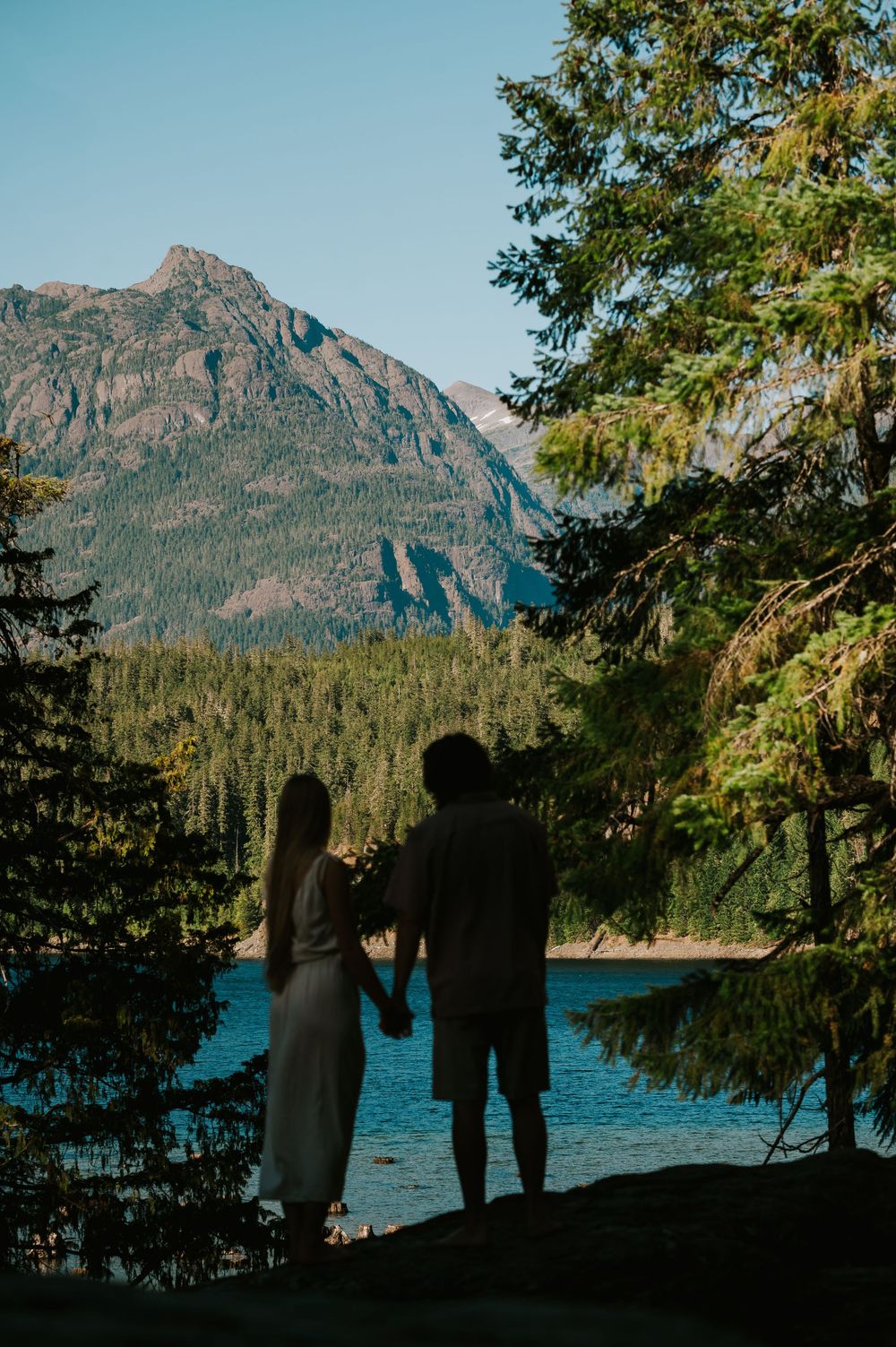 Couple adventure photoshoot session at Myra Falls on Vancouver island taken by professional photographer of couple beside mountain