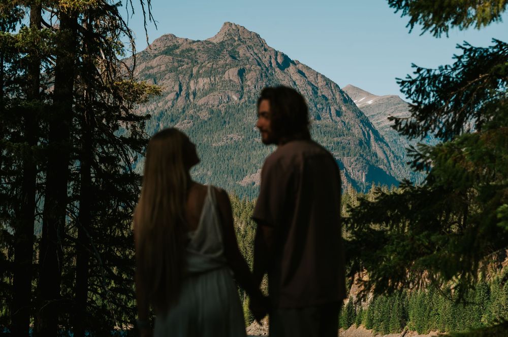 Couple adventure photoshoot session at Myra Falls on Vancouver island taken by professional photographer of couple beside mountain