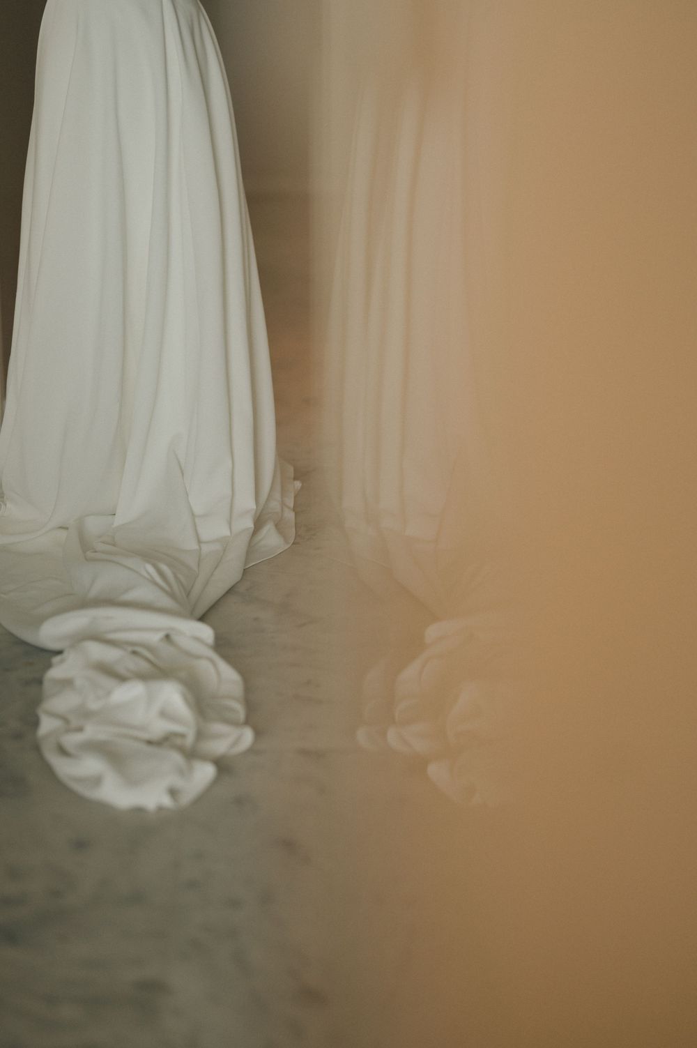 A series of images showing white fabric or dress material draped and pooled on a beige floor.