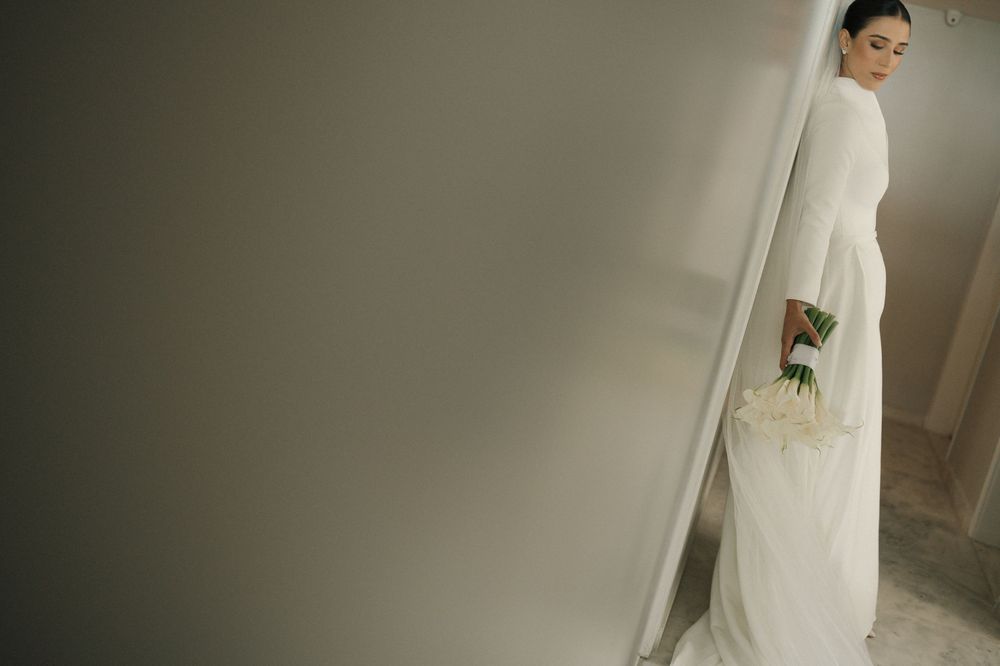 Elegant bridal preparations in a softly lit room with white decor and flowing fabrics.