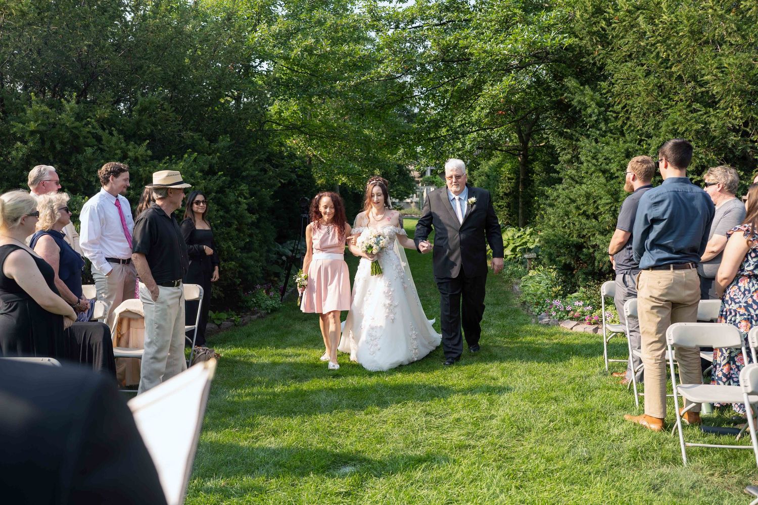 Bride walks down outdoor aisle with father at greater Cleveland Aquarium