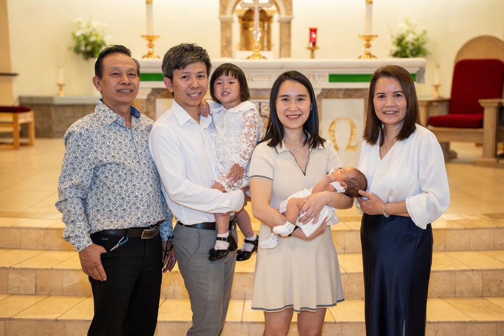 Multigenerational family portrait inside Holy Spirit Catholic Church after a baptism in Tempe, AZ, by N&D Media Production.