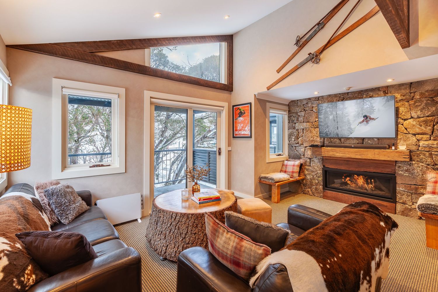 Modern mountain lodge interior with stone fireplace and cozy rustic furnishings.