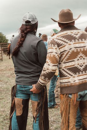 Two ranchers wearing traditional western gear with southwestern pattern sweater.