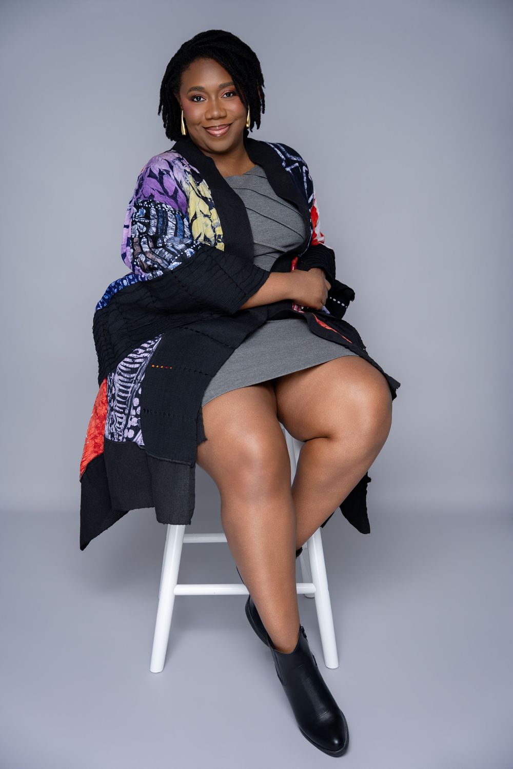 A series of fashion portraits showing someone posing on a white chair wearing a black and patterned jacket with heels.