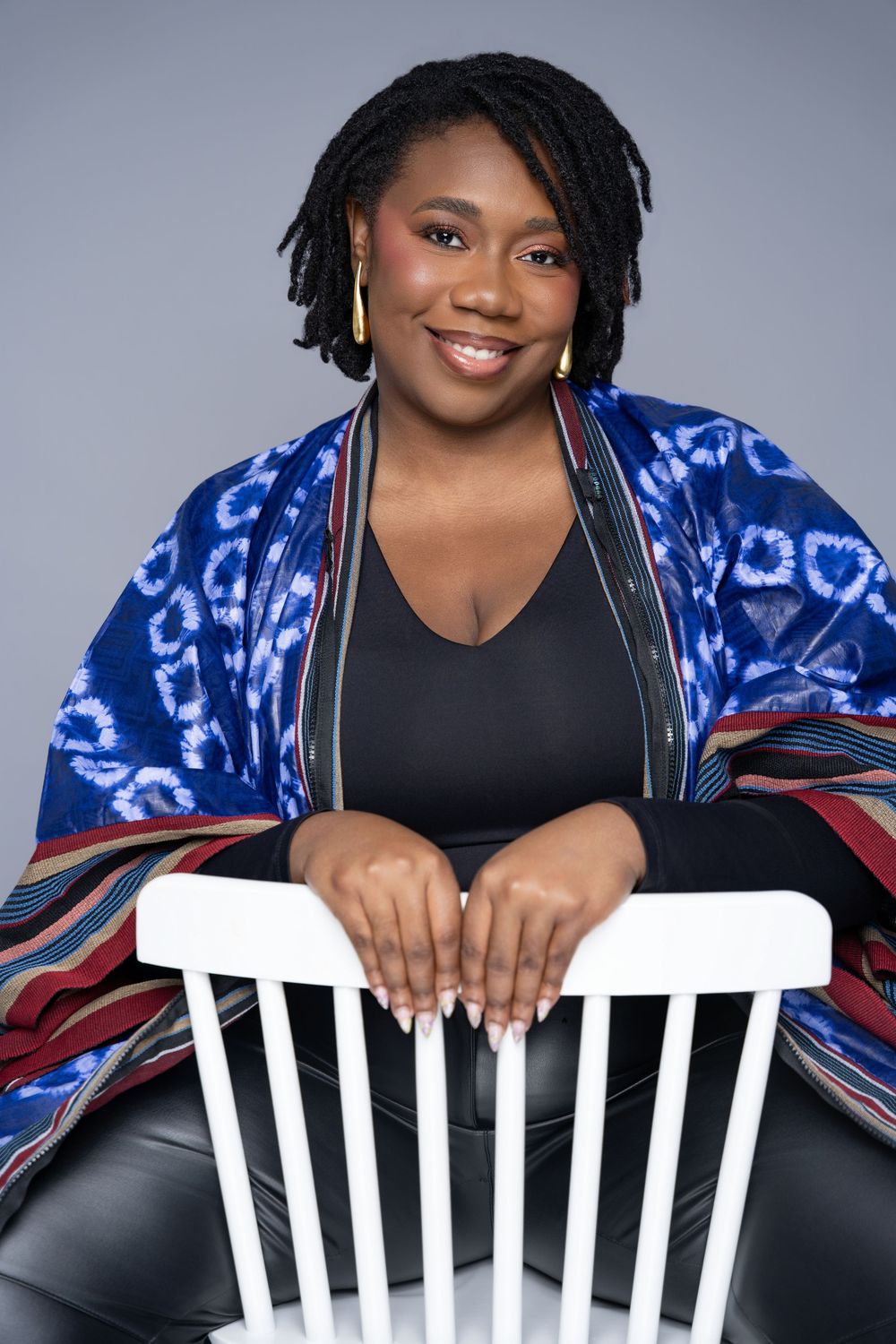 A series of professional portrait photos showing someone in a black top against a blue and white patterned backdrop.