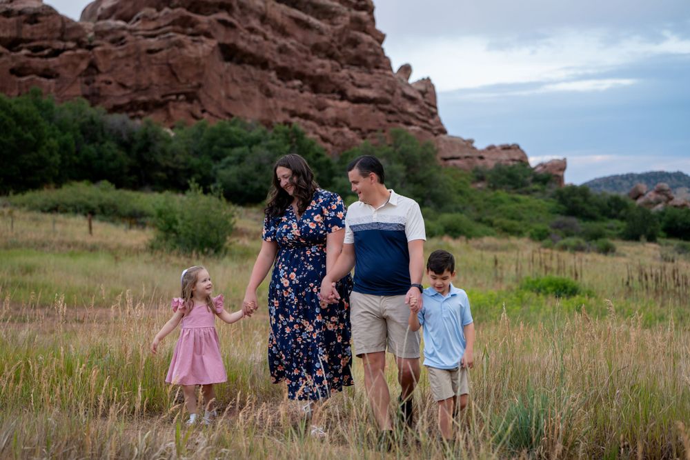 A family walking together against dramatic red rock formations at a natural park.