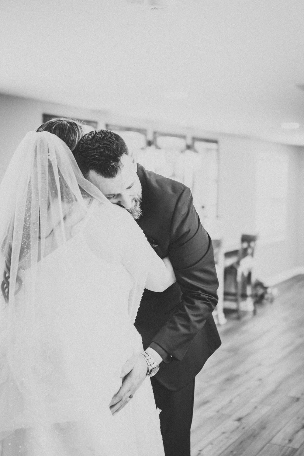 Intimate black and white photo of newlyweds sharing a tender moment during their first dance.