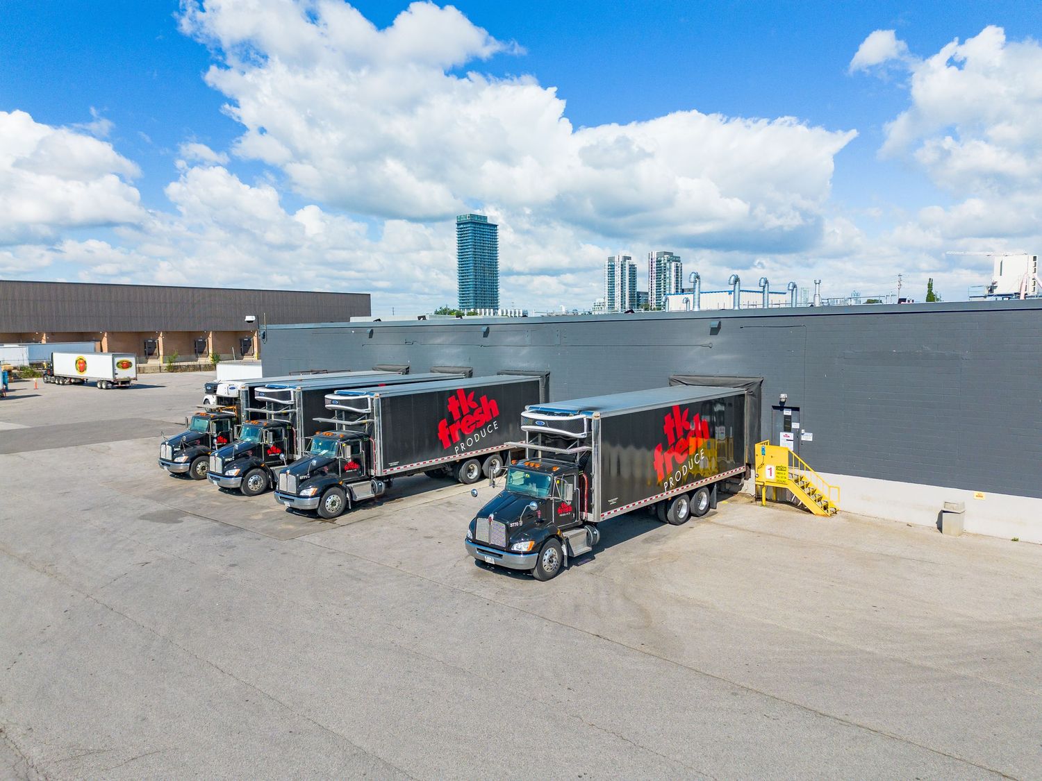 Aerial view of commercial loading docks with semi trucks at a distribution center.