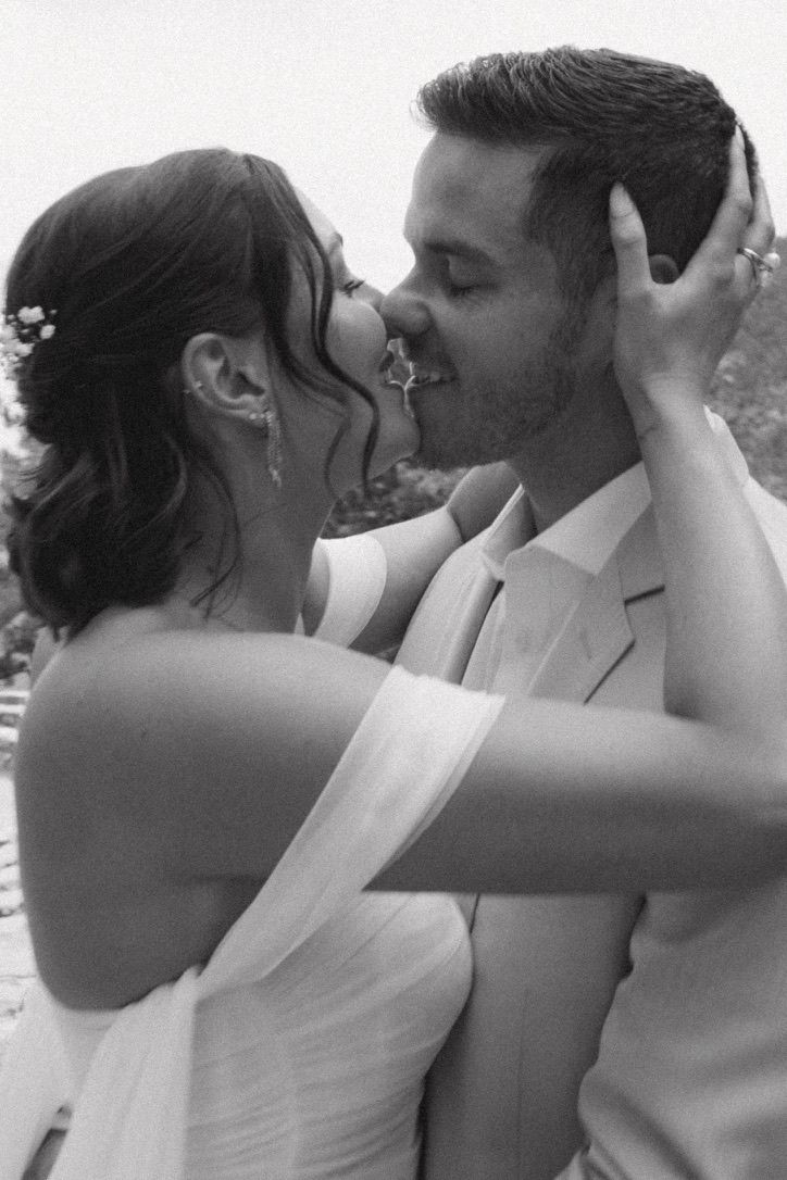 Black and white photo of bride and groom kissing on wedding day.