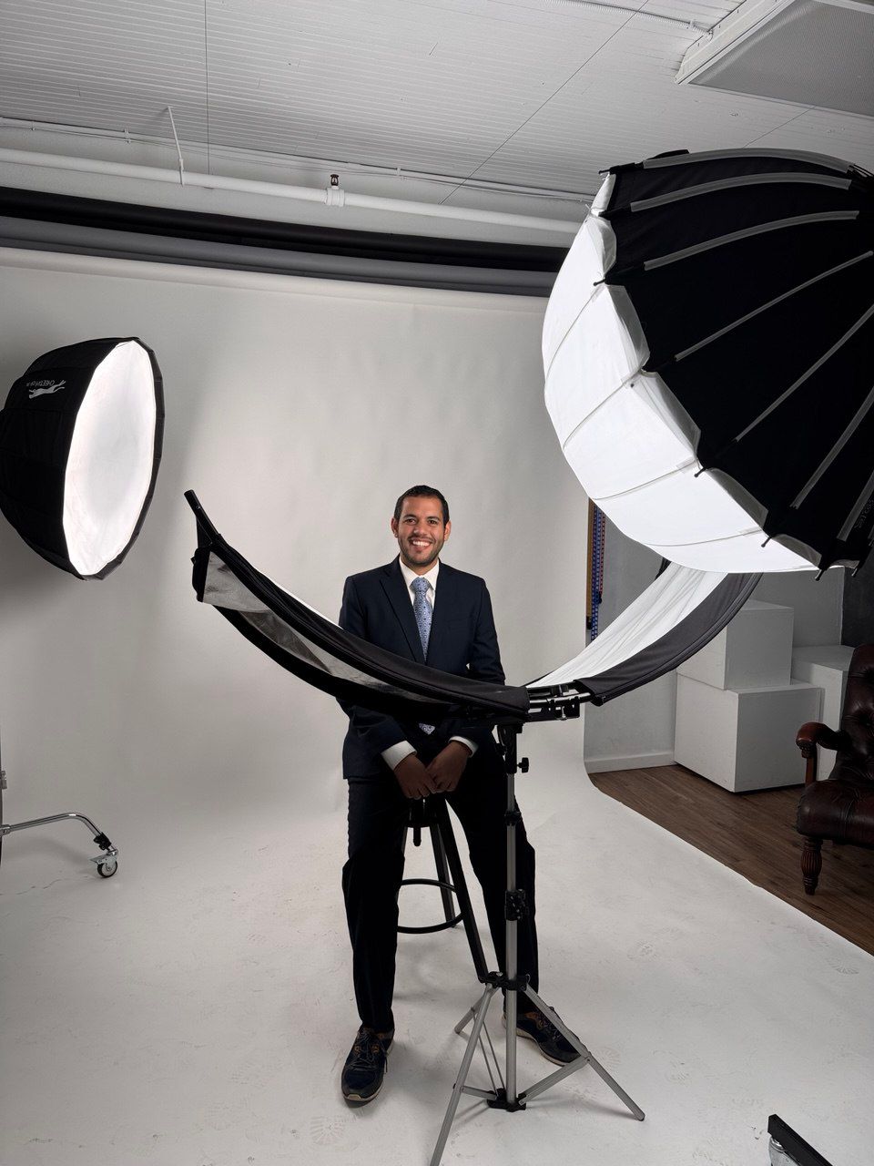 Professional photographer demonstrating lighting equipment in photo studio setting.