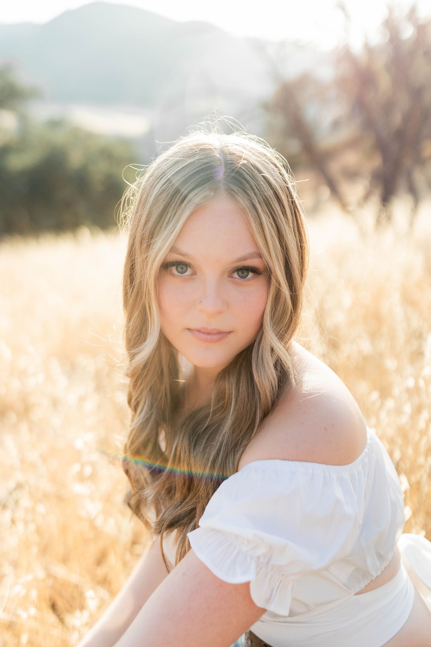 Portrait series in golden field with soft sunlight and dreamy atmosphere.