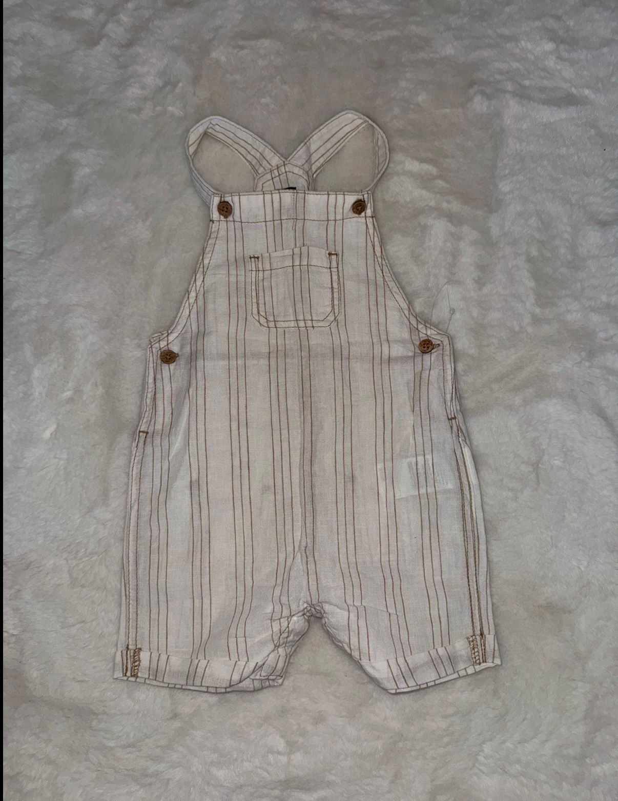 Beige and brown striped baby overalls with button details.
