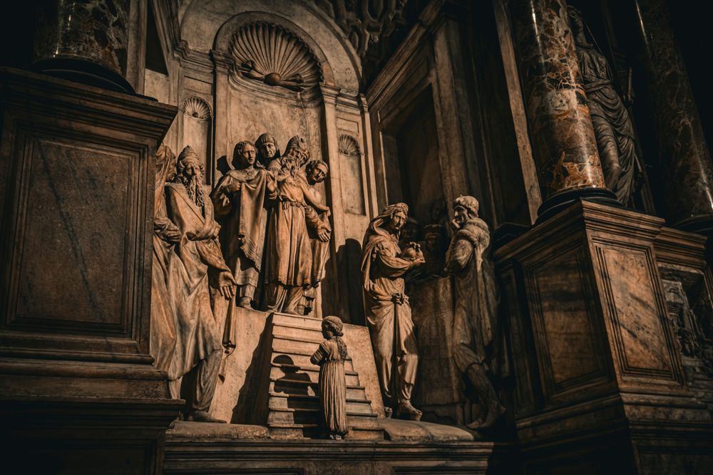Sepia toned sculptural relief showing religious figures gathered on cathedral steps.