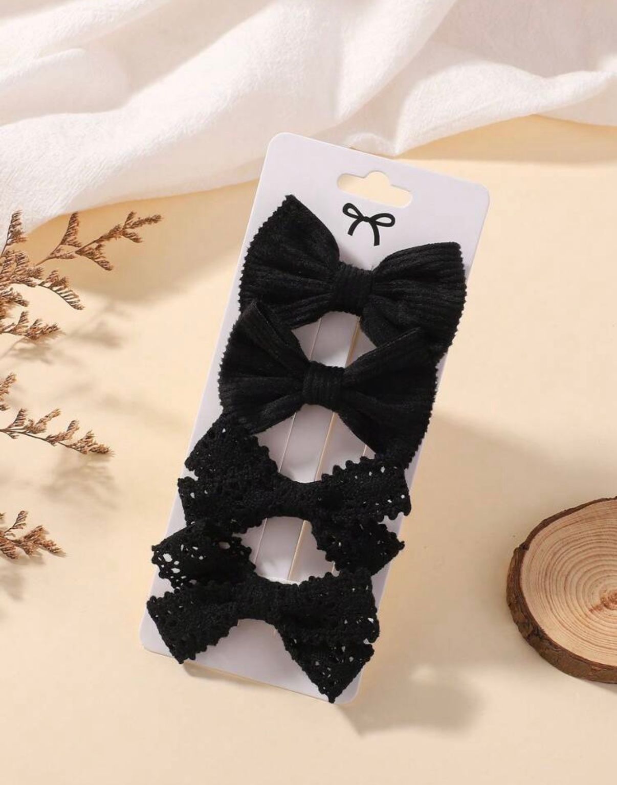 Black bow hair accessories with sequins and sparkles displayed on a light background.