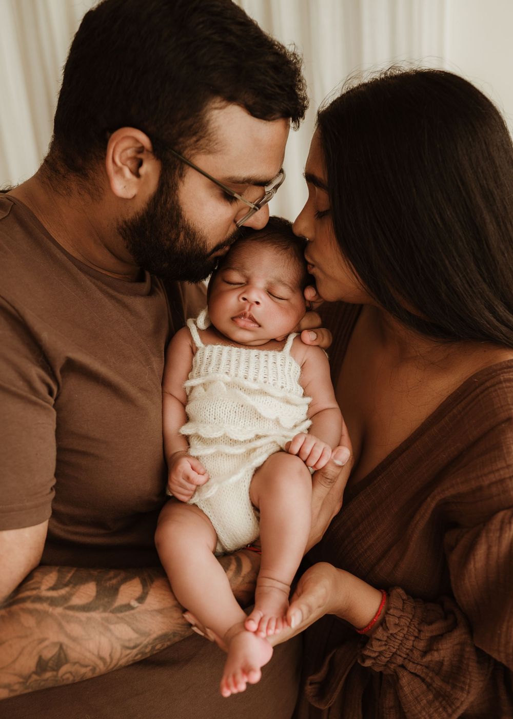 A series of intimate family photos showing tender moments between parents and their baby in brown toned clothing.