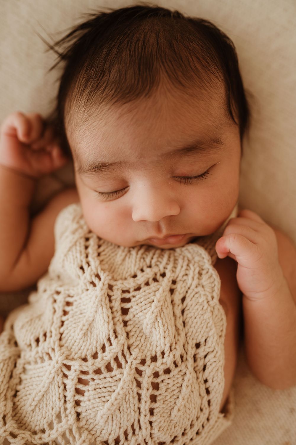 Close-up series of a sleeping infant wearing a cream knit blanket in soft neutral tones.