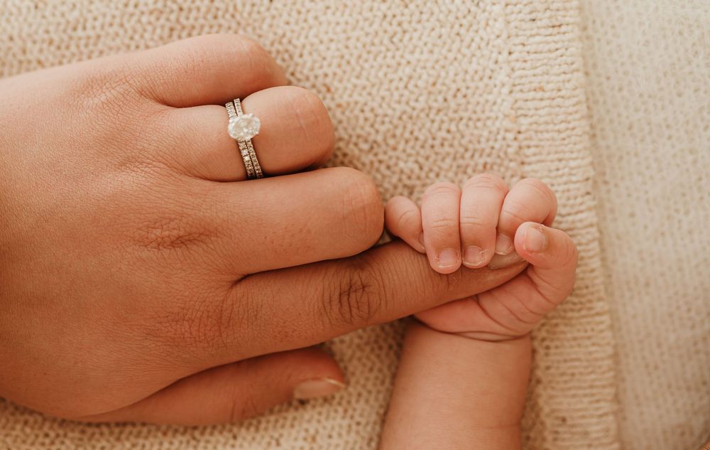 Closeup macro sequence showing hands with wedding bands intertwining fingers against a beige textured backdrop.