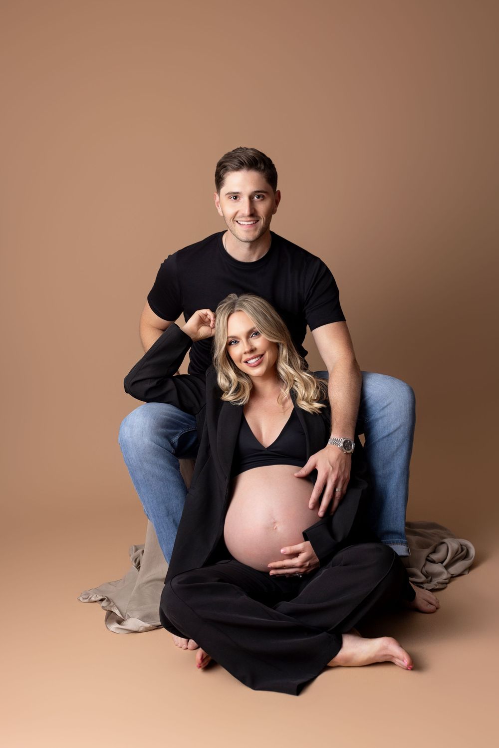 A fun couples maternity shoot, with mother exposing belly and dad proudly grinning!