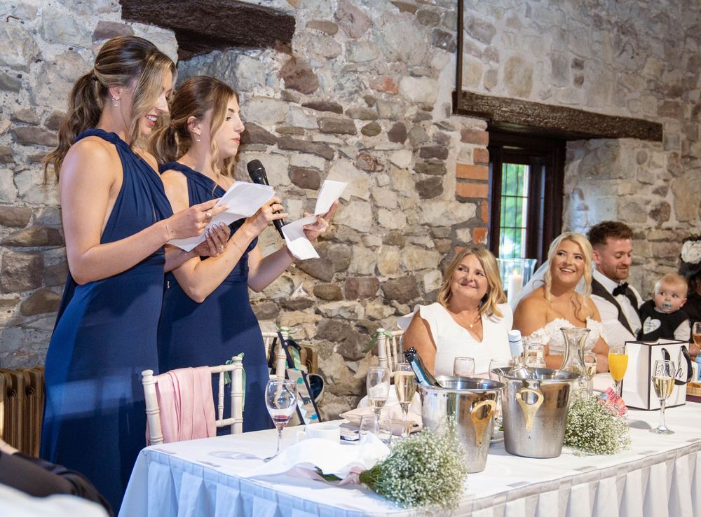 Wedding reception setup with tables and navy blue decor in rustic stone venue.