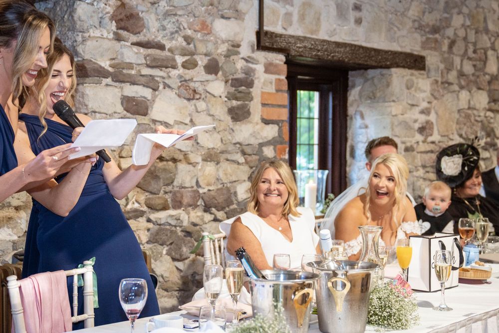 Wedding celebration in progress at rustic stone venue with guests seated at decorated tables.
