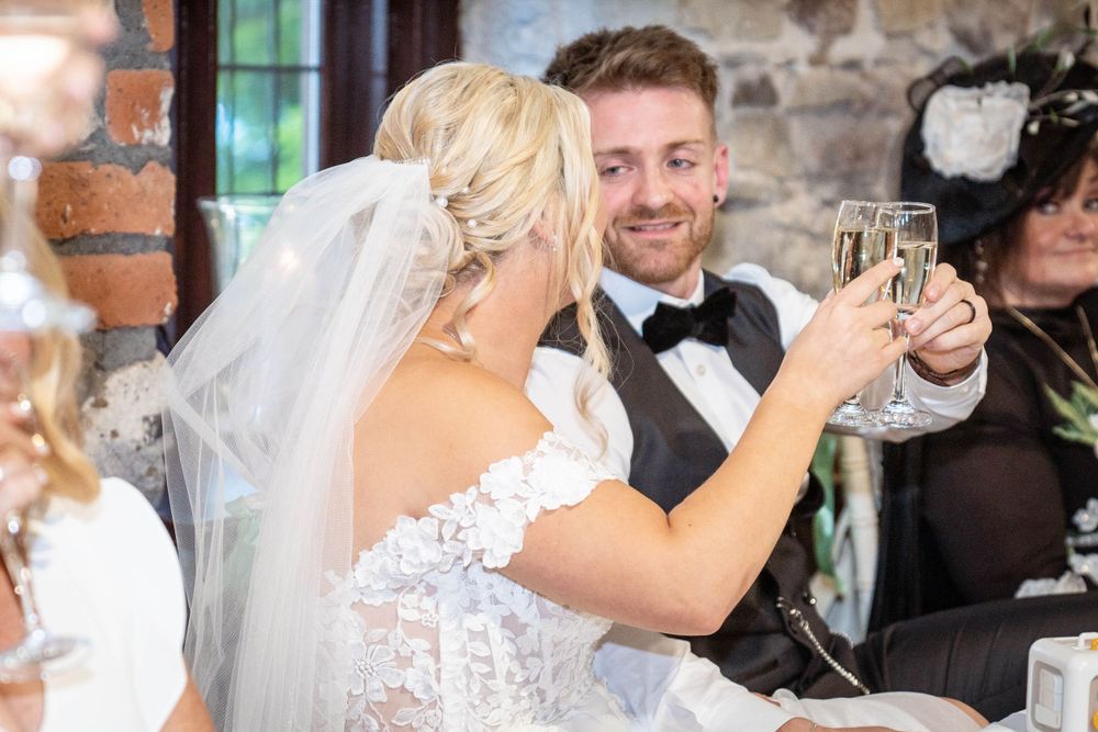 Wedding celebration with overhead string lights and stone walls creating a warm atmosphere.