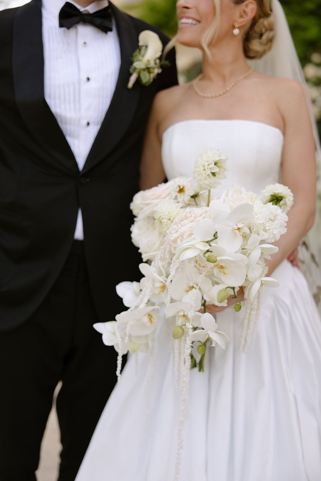 Wedding champagne glasses decorated with grey ribbons arranged in rows.