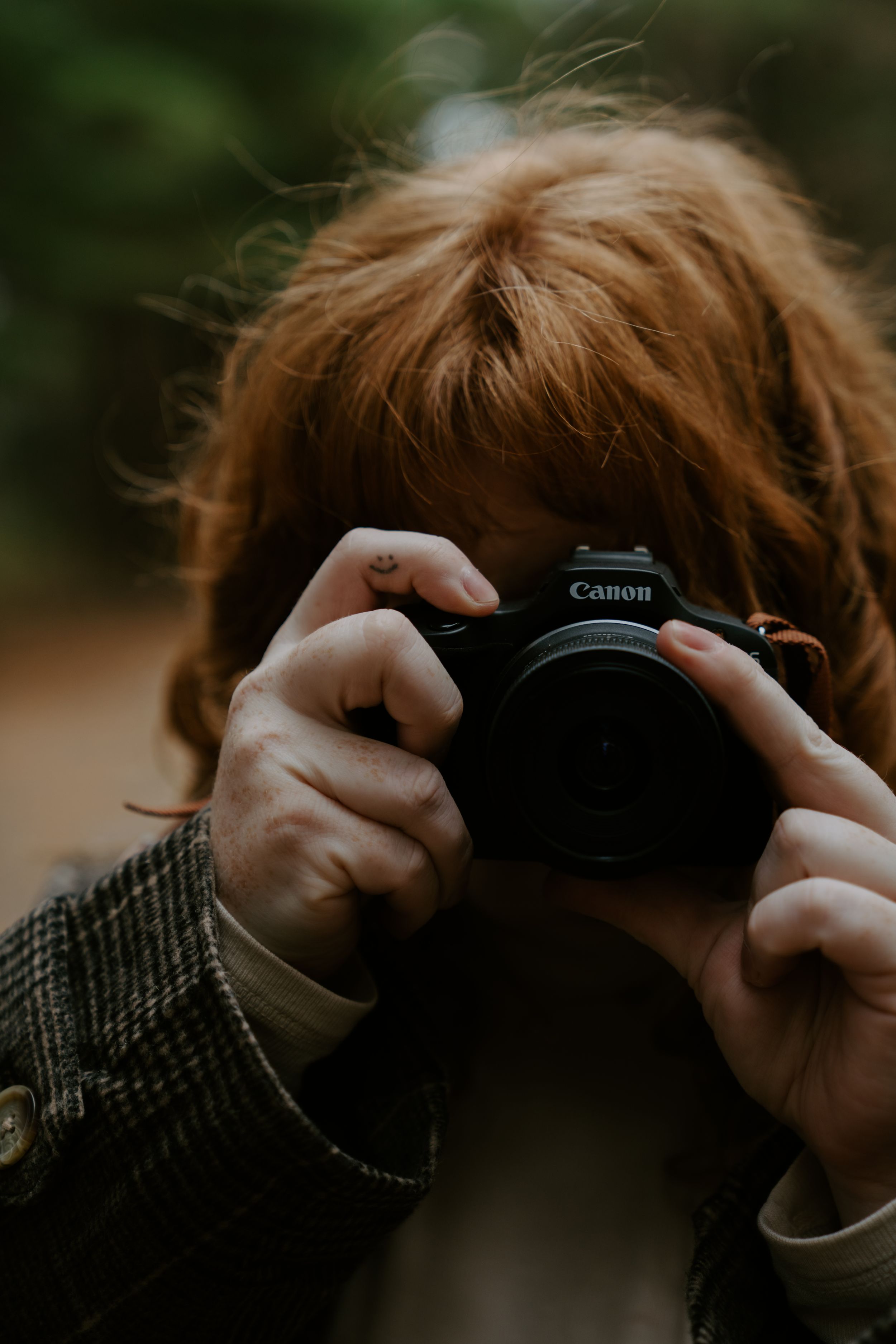 Close-up shots of hands holding a Canon camera against a blurred background.