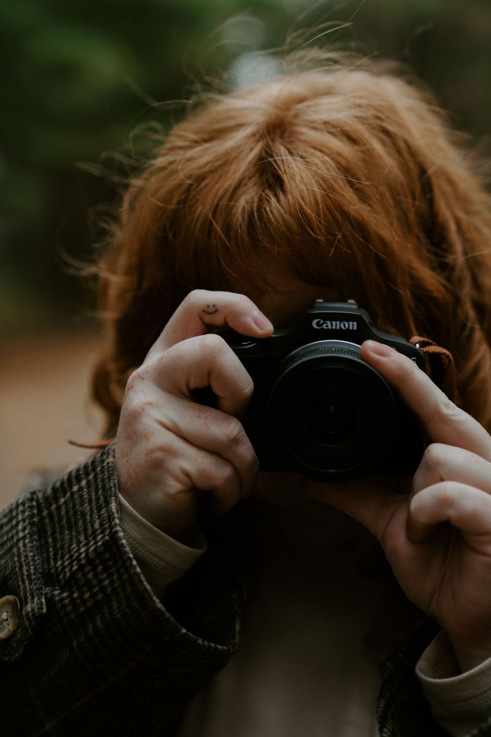 Close-up shots of hands holding a Canon camera against a blurred background.