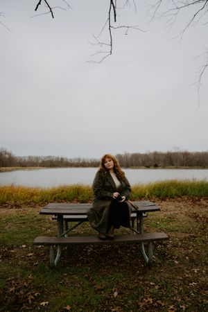 Atmospheric shots of someone sitting on a bench near a misty lake in fall.