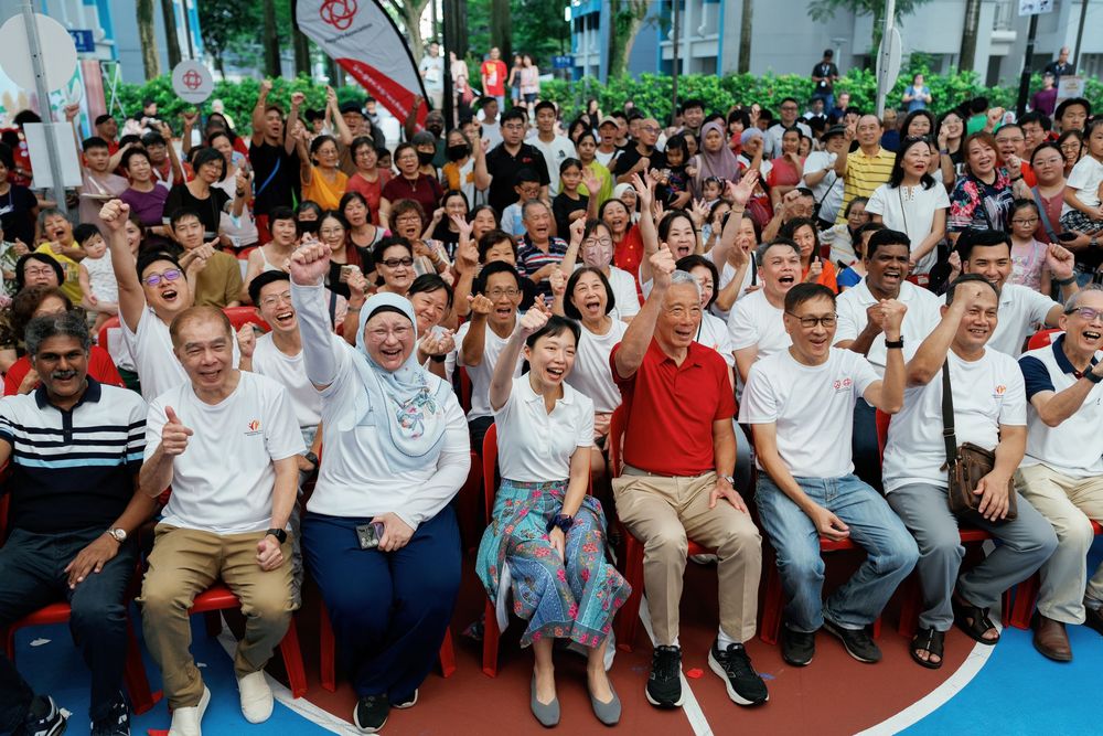 A large crowd of spectators in white and casual attire seated together watching an event or performance.