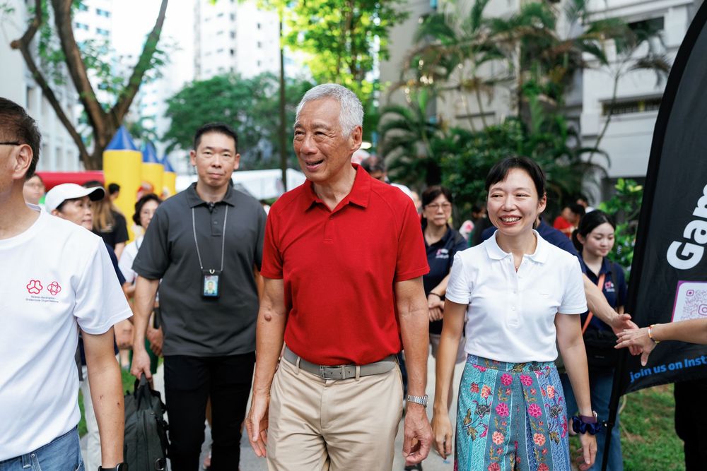 People gathered outdoors at a family day event with participants wearing red and white casual attire.