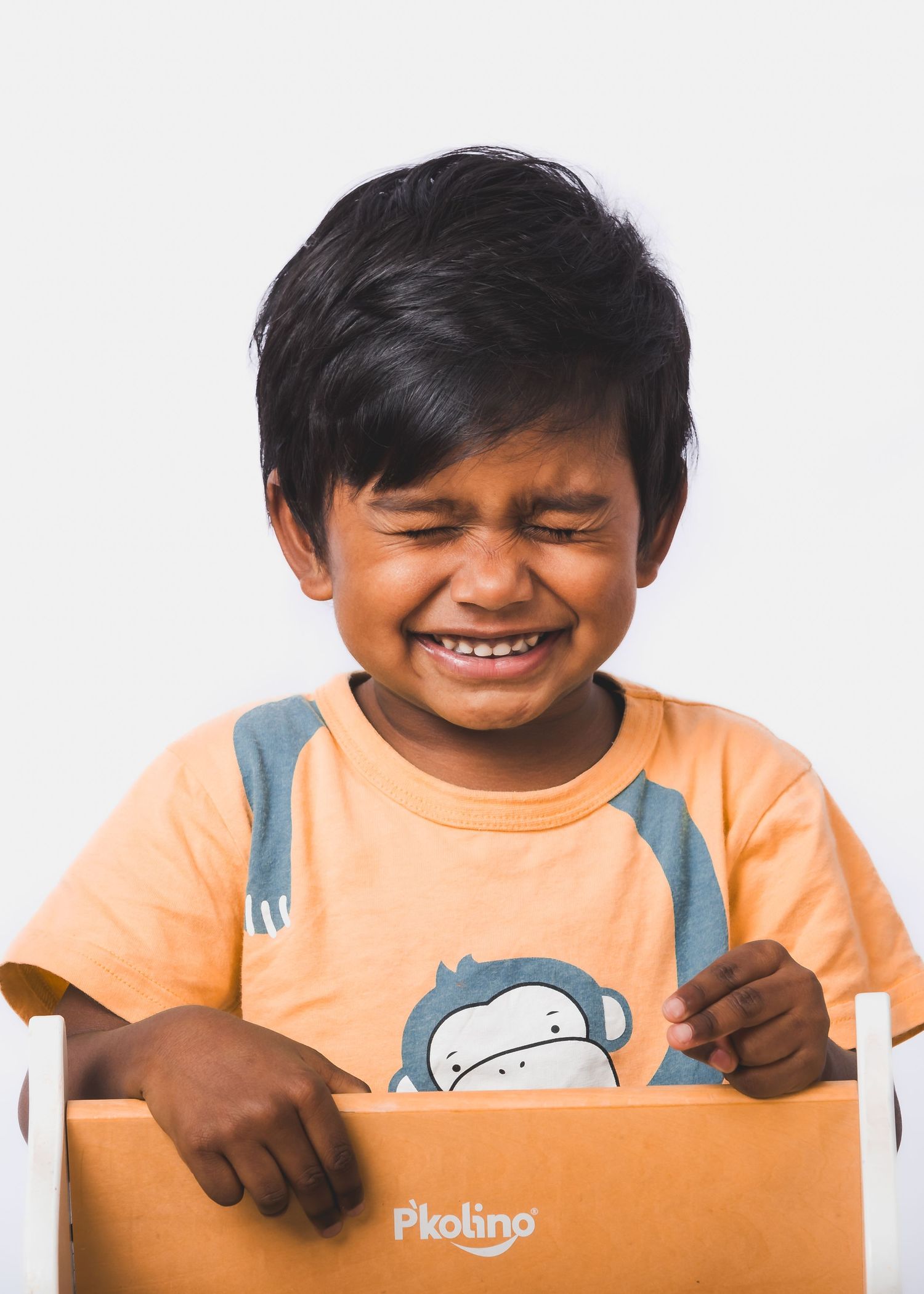 Young child in orange t-shirt White Background minimalistic