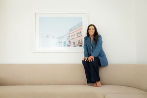 Professional seated portrait series featuring relaxed poses against minimalist backgrounds.
