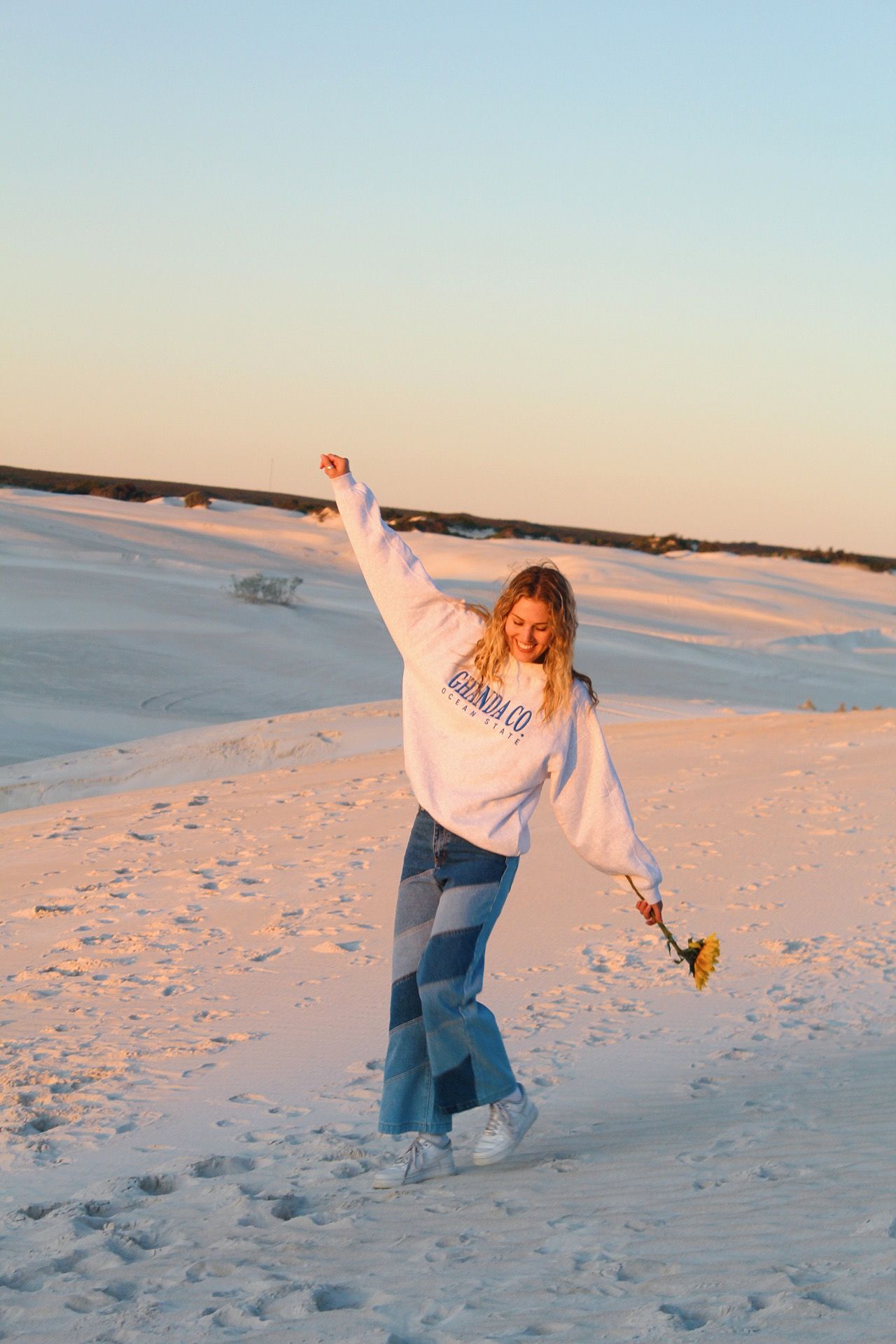 Collection of photos showing playful moments on white sandy dunes during sunset.