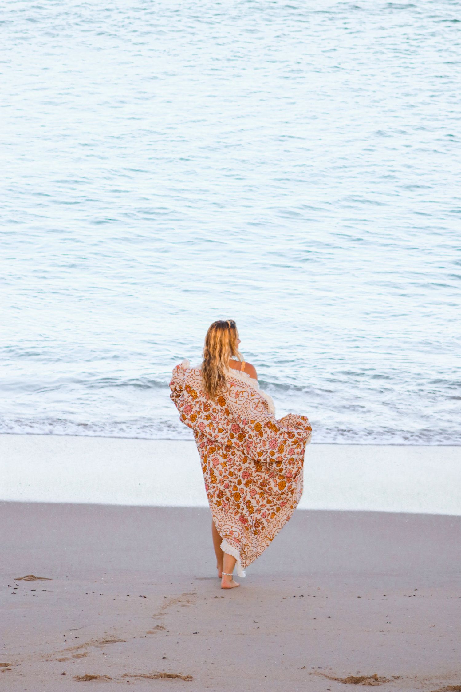 Sequence of beach photos showing flowing floral dress movement against ocean waves.